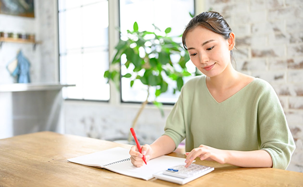 女性が家計簿をつけている