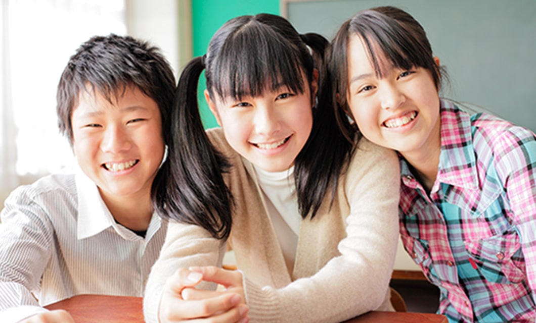 ３人の高校生が肩を寄せ合っている