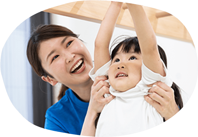 うんていをする女の子とそれを支えるスタッフ