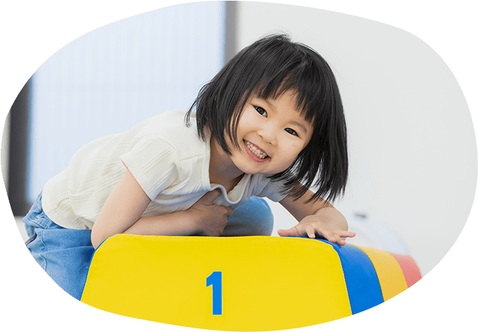 子供が跳び箱に登っている