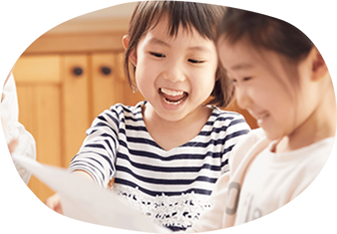 友達の持っているプリントを指先している小学生の女の子