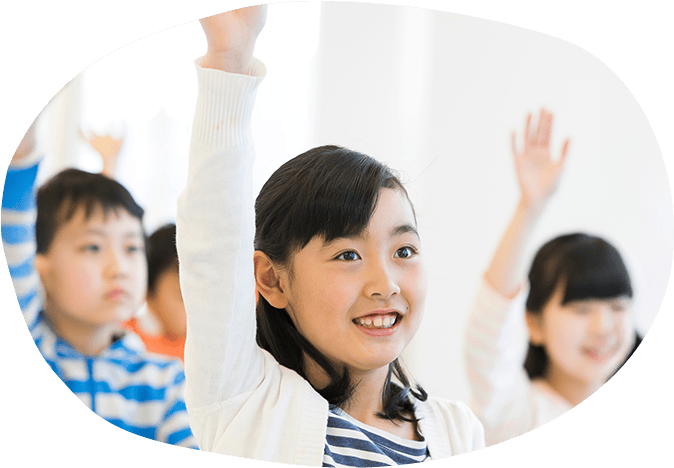 笑顔で挙手している小学生